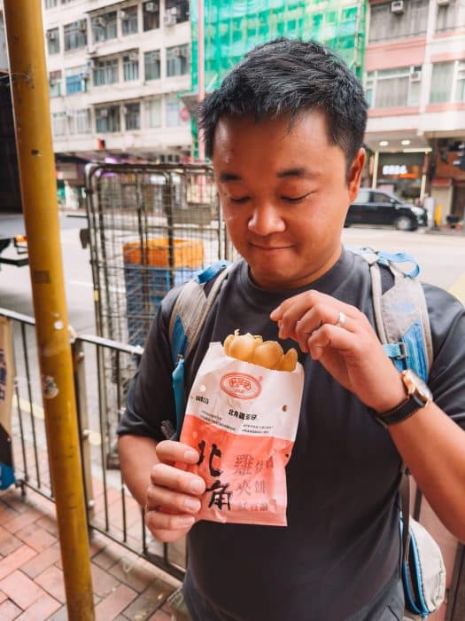 Andy eating an original egg waffle, best things to do in Hong Kong