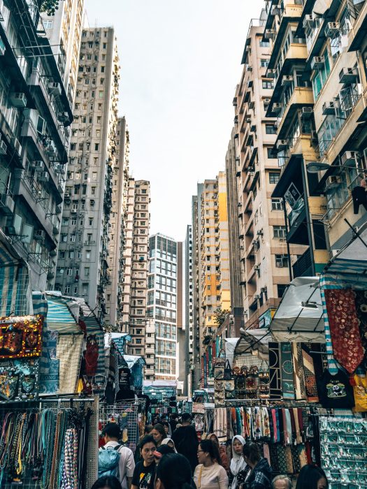 Market stalls nestled beneath towering skyscrapers in Mong Kok, Ladies Market, Hong Kong Itinerary