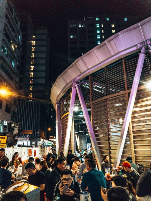 A busy open-air eatery with people socialising and eating at Woosung Street Temporary Cooked Food Hawker Bazaar, Hong Kong Itinerary