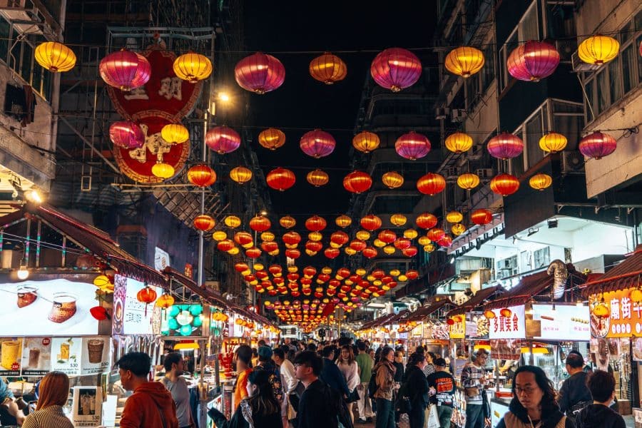 Rows of lanterns above market stalls hanging between buildings at Temple Street Night Market, Things to do in Hong Kong at Night