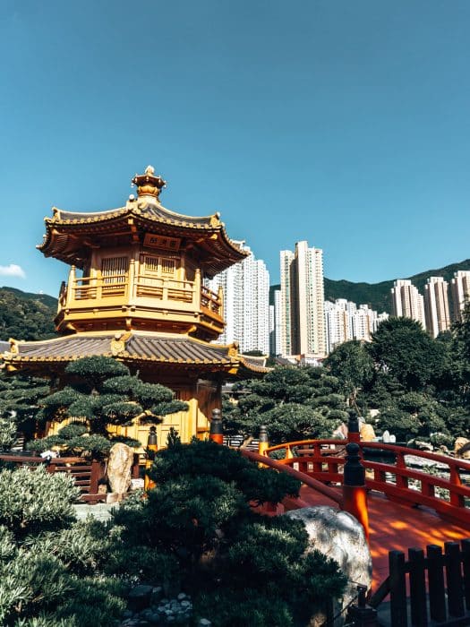 A golden pavilion in a pond with huge skyscrapers behind it at Nan Lian Garden, Places in Hong Kong