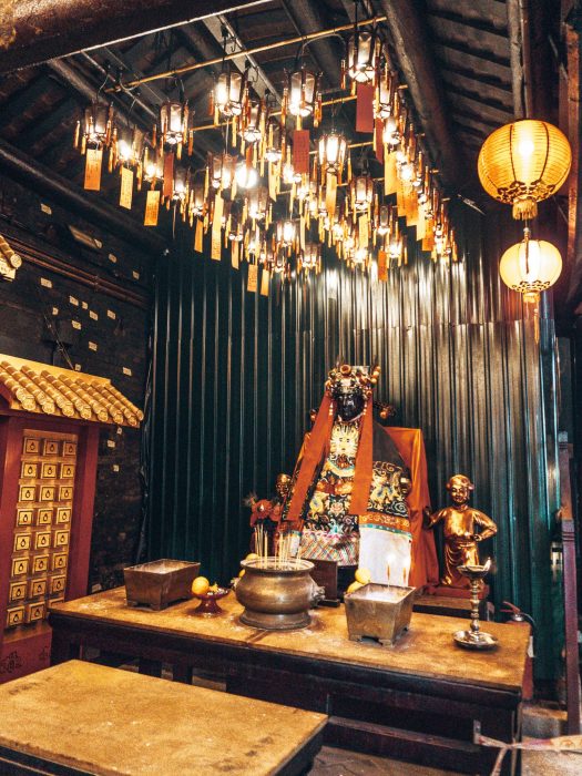 The inside of Man Mo Temple with messages hung from the ceiling and intricate statues, Things to do in Hong Kong