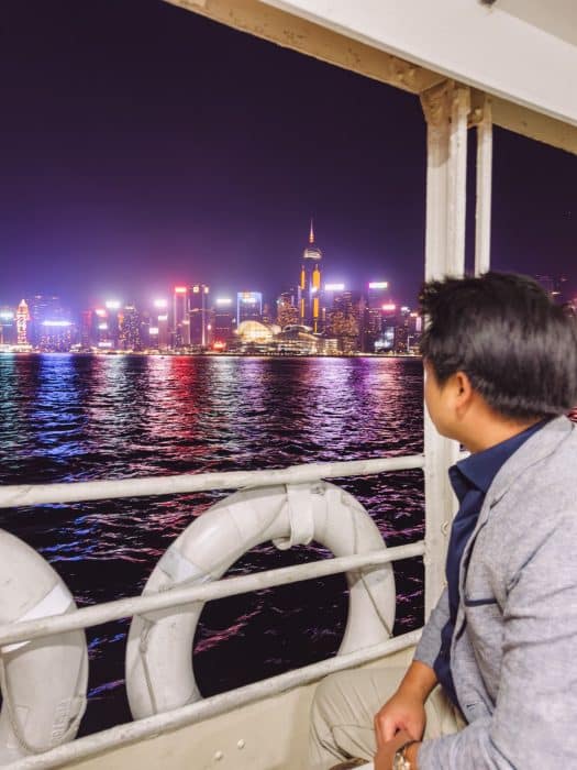 Andy sitting on the Star Ferry at night with the skyscrapers lit up, 5 Days in Hong Kong