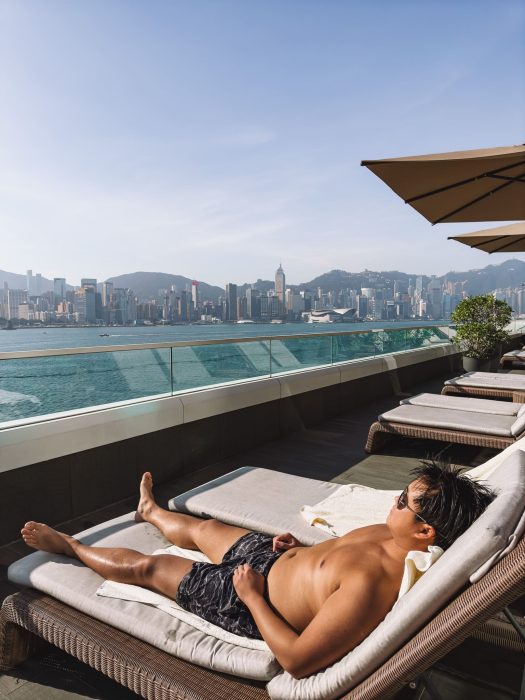 Andy on a sunbed overlooking Victoria Harbour and Hong Kong Island, The Kerry Hotel, Kowloon, Hong Kong