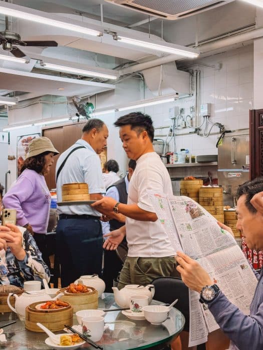 Andy collecting dim sum from a trolley in Lin Heung Lau, Hong Kong Itinerary