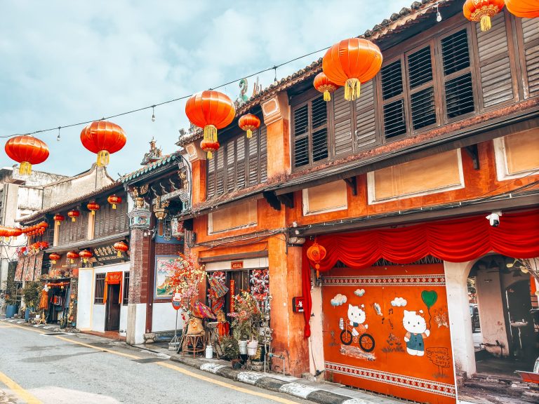 A row of colourful red houses with red lanterns hanging across the street, best things to do in Penang