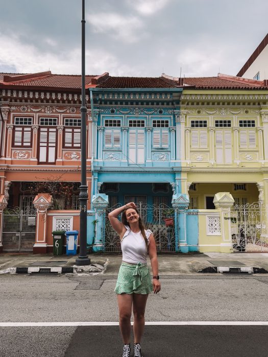 Helen walking in front of a row of multi-coloured Peranakan houses, Katong Joo Chiat, Singapore Itinerary