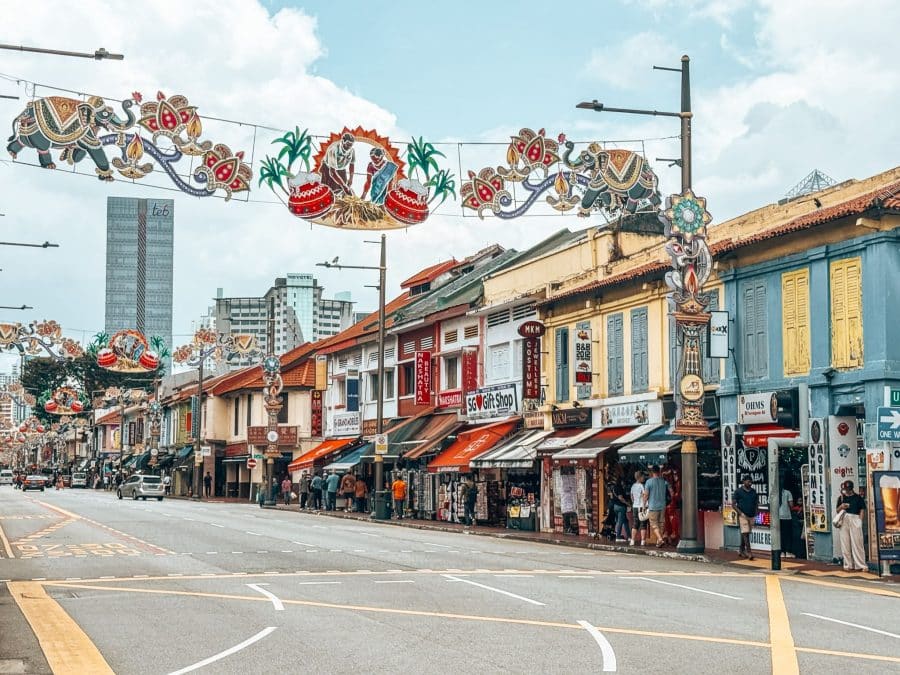 A road lined with colourful traditional shophouses and bright decorations hanging above the street, Little India, Singapore Itinerary
