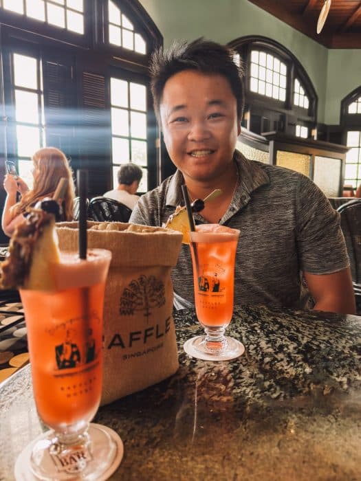 Andy with a cocktail and a bag of peanuts in Long Bar, Raffles Hotel, Singapore Itinerary