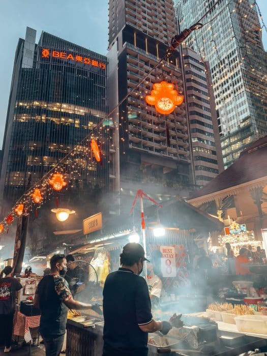 People BBQ'ing satay skewers underneath huge skyscrapers, Lau Pa Sat, where to eat in Singapore