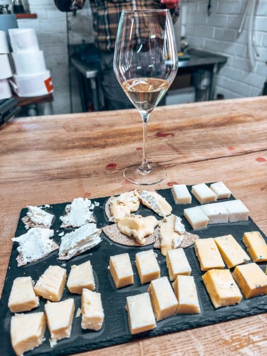A board of cheese with a glass of wine at The Wharie Experience, wine tasting in the New Forest