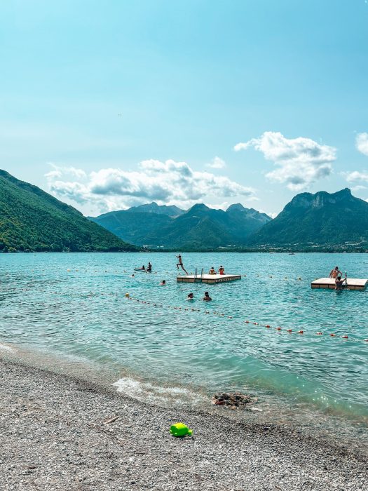 People jumping off pontoons in Lake Annecy, Angon Beach, France