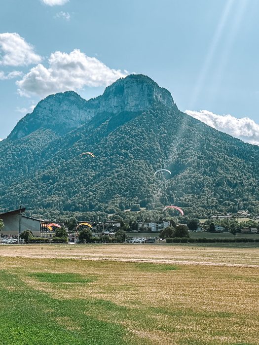 Paragliders landing in the countryside surrounding Lake Annecy, France