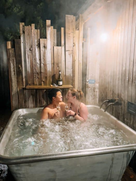 Helen and Andy drinking champagne in the outdoor spa bath at the Tawny Hotel, luxury hotels in Staffordshire