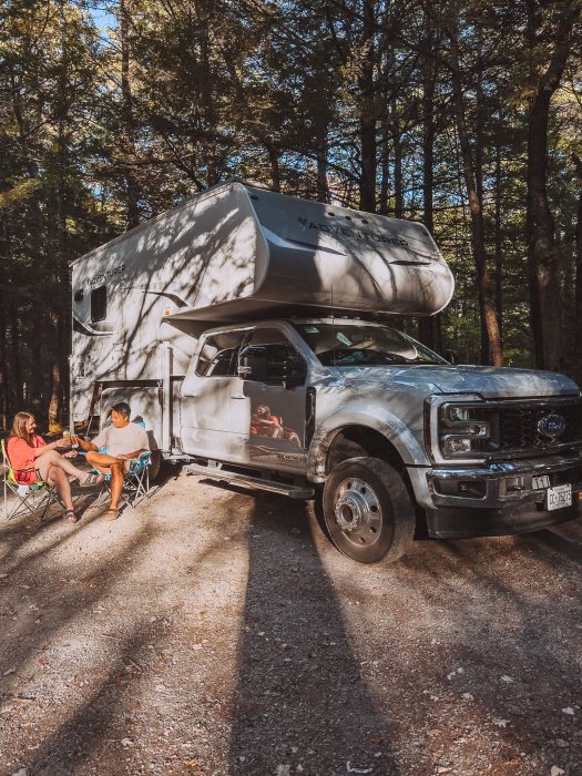 Helen and Andy sitting outside their motorhome chatting while Camping at Kejimkujik National Park, getting around Nova Scotia