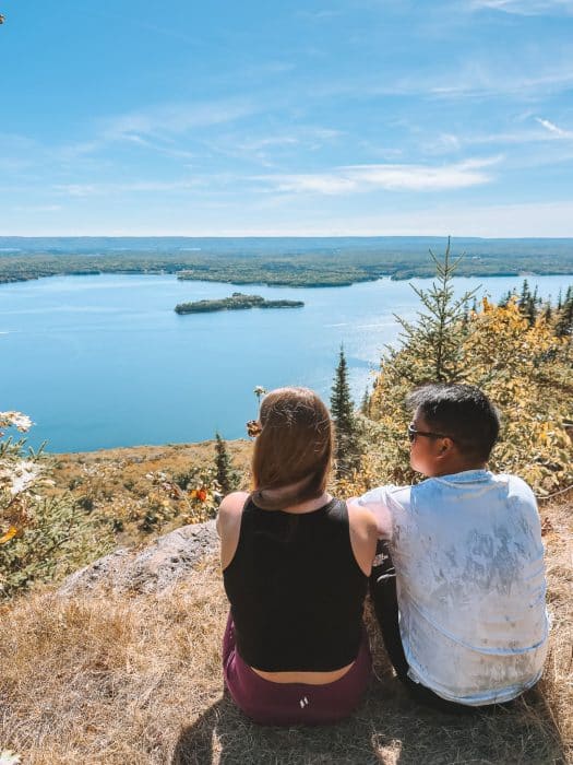 Helen and Andy sitting at the peak of Salt Mountain gazing out over Bras d'Or Lake, Whycocomagh Provincial Park, Places to Visit in Nova Scotia