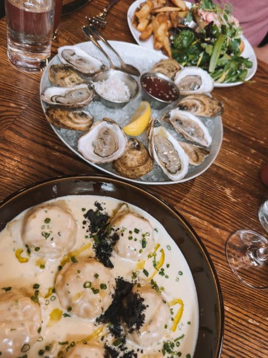 A plate of lobster ravioli, oysters and a lobster roll at Black Sheep, restaurants in Halifax, Nova Scotia