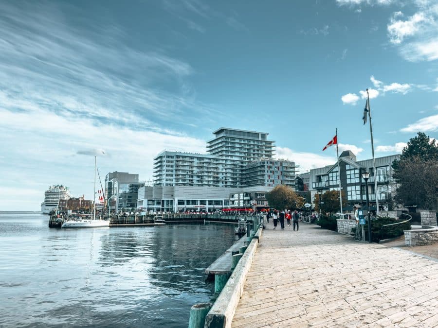 A wooden boardwalk next to the ocean with buildings, Halifax Boardwalk, things to do in Nova Scotia, Canada