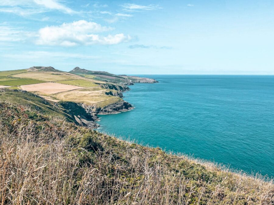 Turquoise ocean next to rolling green countryside, 3 day Pembrokeshire itinerary, Wales